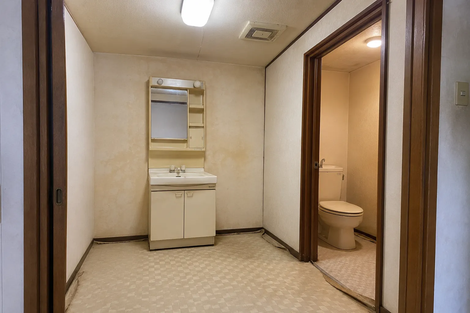 改修前の洗面台とトイレを表したAI生成画像