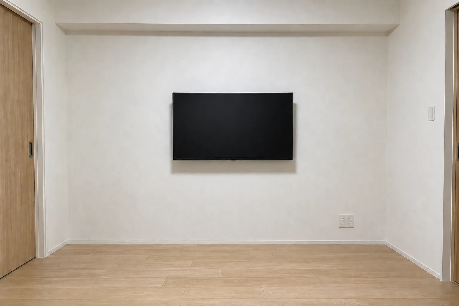 壁掛けテレビを設置し、配線を壁の中に隠した居室